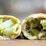 cross section of an empanada filled with broccoli and cheddar