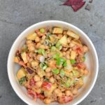 bowl of chickpeas and vegetables in creamy cashew dressing on slate background