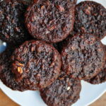 chocolate zucchini muffins piled on a white plate
