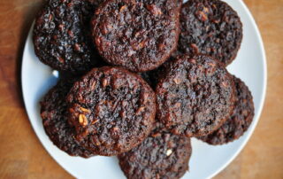 chocolate zucchini muffins piled on a white plate