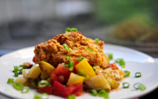 zucchini and tomato savory summer cobbler on a white plate