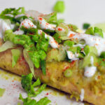 black bean enchiladas topped with melted cheddar, lettuce and sour cream