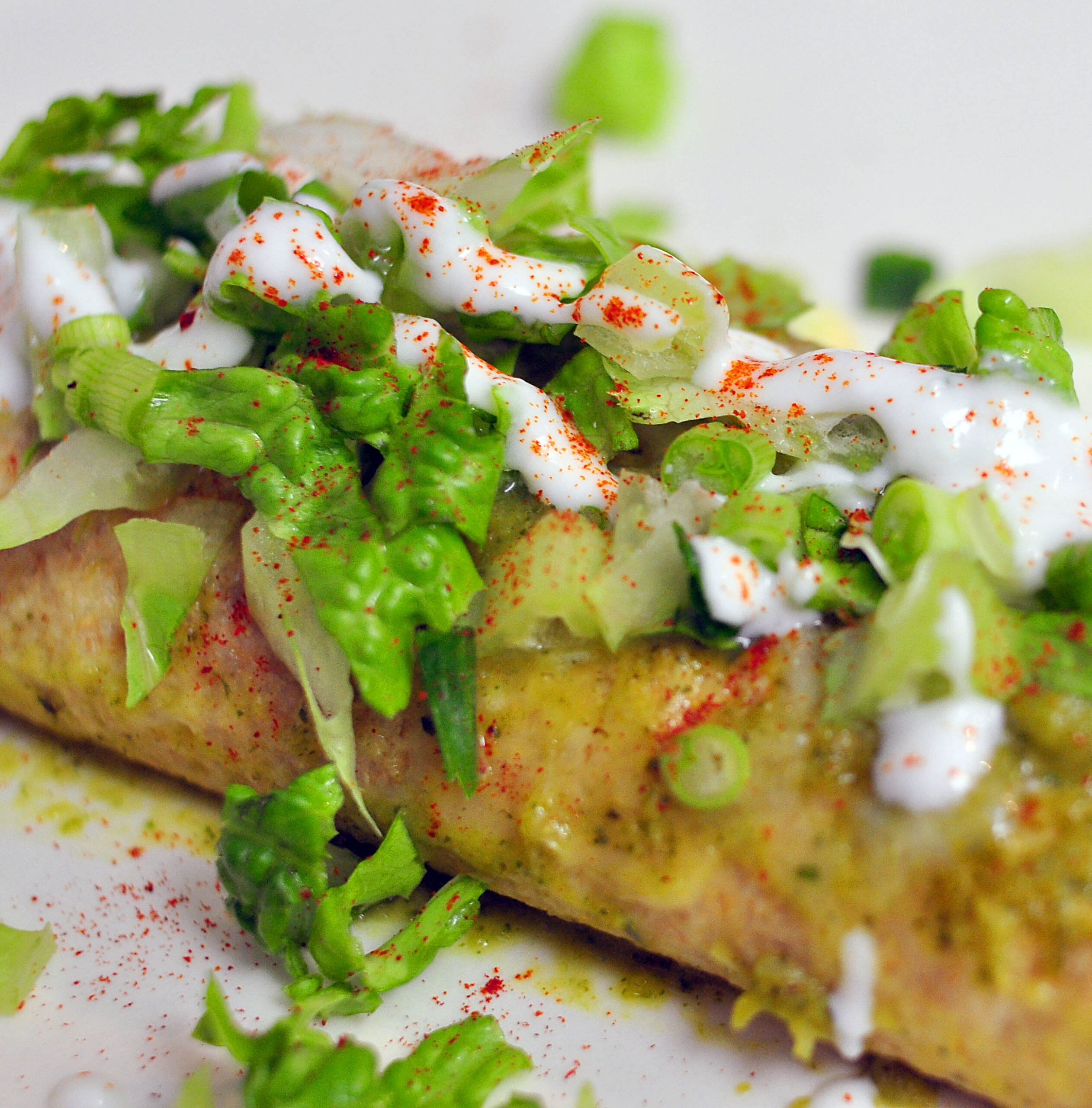 black bean enchiladas topped with melted cheddar, lettuce and sour cream