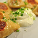 pan-fried pierogi with sour cream and scallions