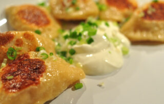 pan-fried pierogi with sour cream and scallions