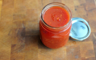 small jar of tomato sauce on wooden board