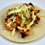 cauliflower tacos with roasted cauliflower rubbed with smoked paprika and topped with cheese and green salsa