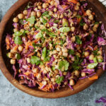 wooden bowl filled with chickpea and vegetables salad