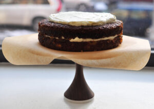 2 layers of carrot-pineapple cake with frosting in the middle and top