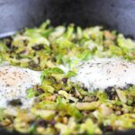 cast iron pan with brussels sprouts hash and eggs