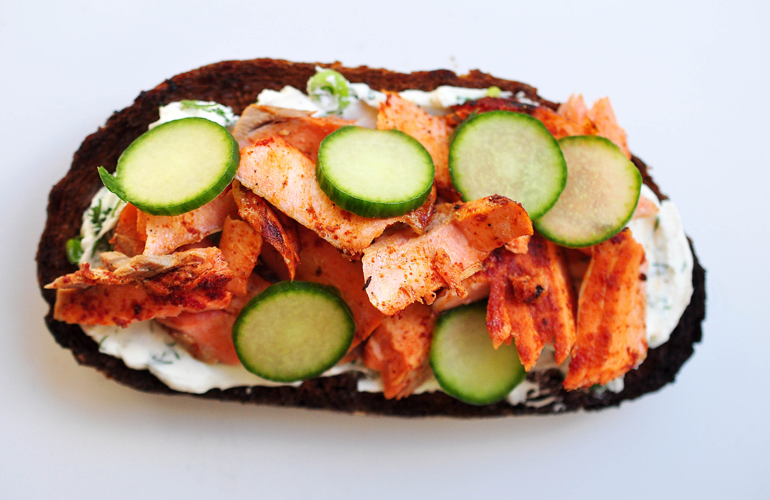 pumpernickel bread with smoked paprika rubbed salmon, cucumbers and dill cream cheese