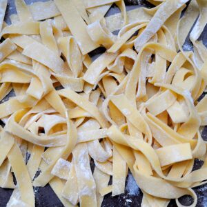 uncooked fresh pasta noodles in a pile tossed with flour