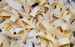 uncooked fresh pasta noodles in a pile tossed with flour