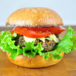 half veggie burger with a beautiful fluffy lettuce and tomato on top