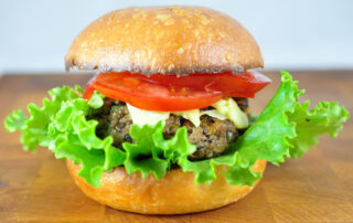 half veggie burger with a beautiful fluffy lettuce and tomato on top